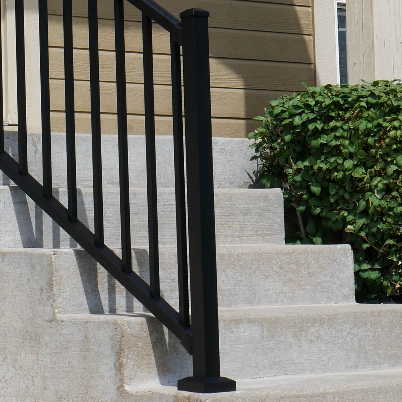 47" aluminum Westbury Textured black stair post on concrete stairs.